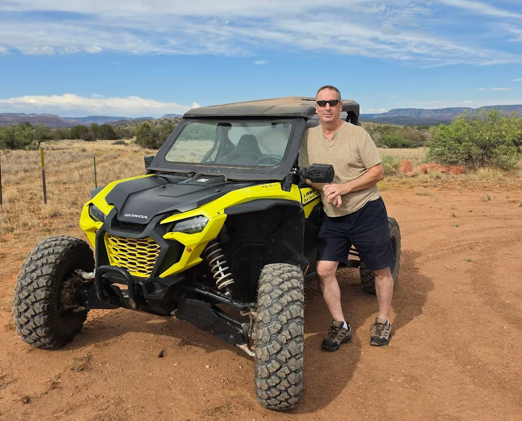 Blog 26 A man leaning against a parked UTV