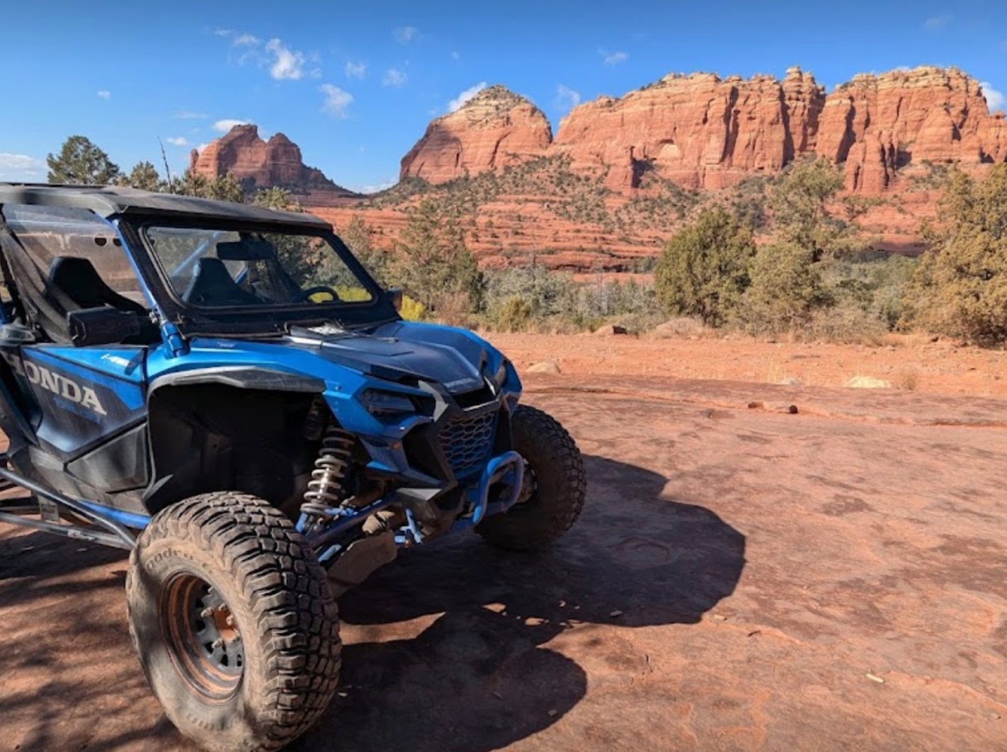 Honda Talon side by side on a red rock trail ready to take off.