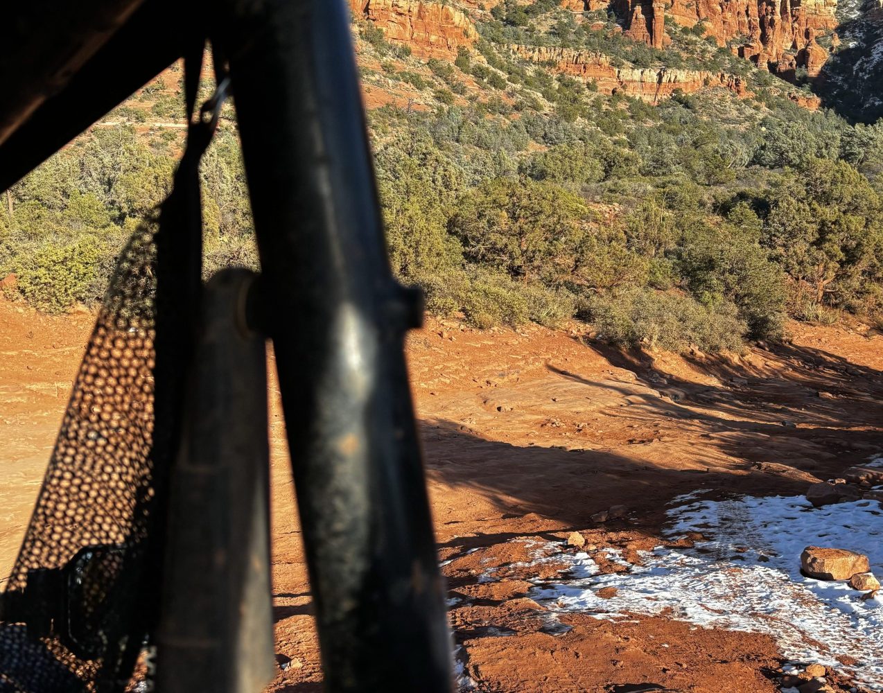 Vibrant northern Arizona landscape featuring dramatic red rock formations, expansive desert vistas, lush sagebrush, and clear blue skies. Capture the essence of off-road adventures with winding dirt trails leading through the rugged terrain, surrounded by towering mesas and scattered cacti.